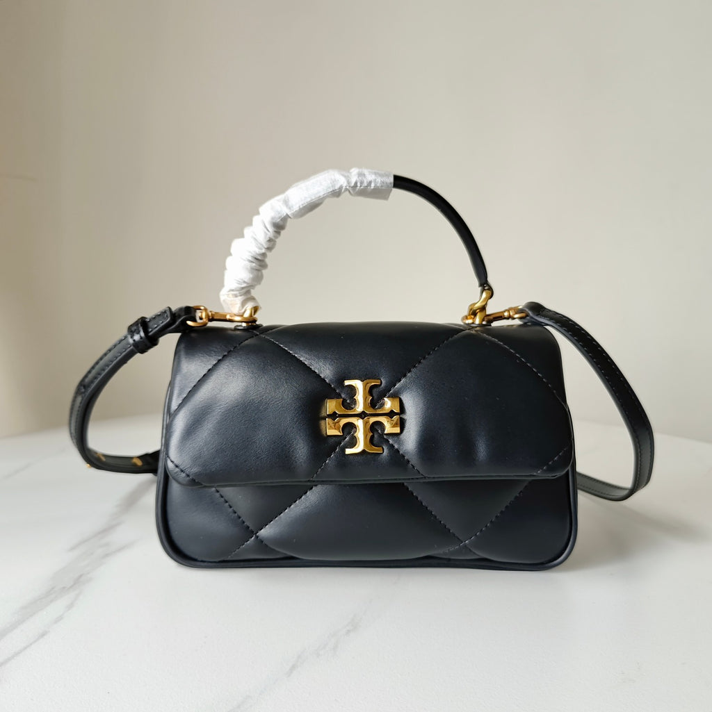 Black quilted crossbody bag with gold logo clasp, curved top handle and shoulder strap