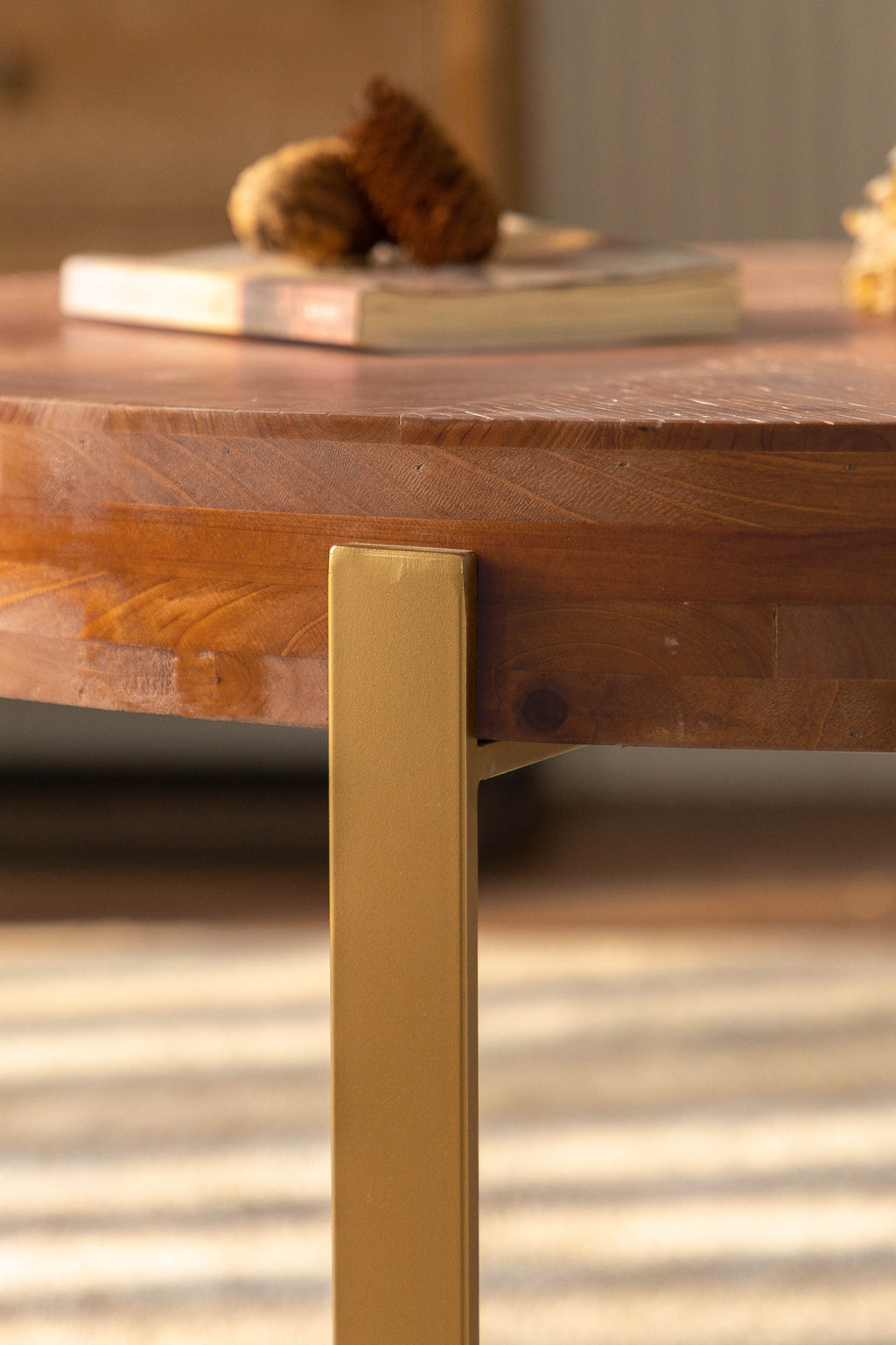 Close-up of fir wood tabletop edge and gold metal leg corner
