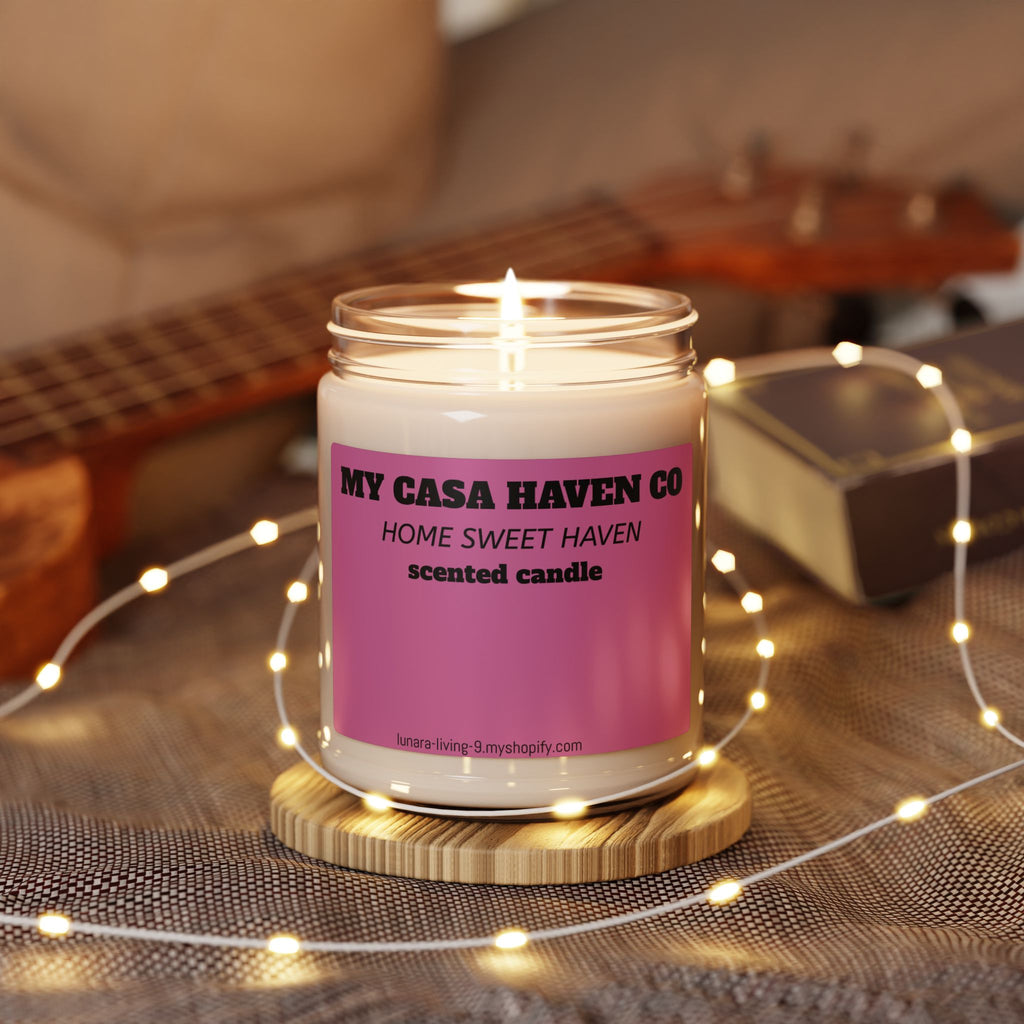Scented soy candle in clear glass jar with flame burning, purple label