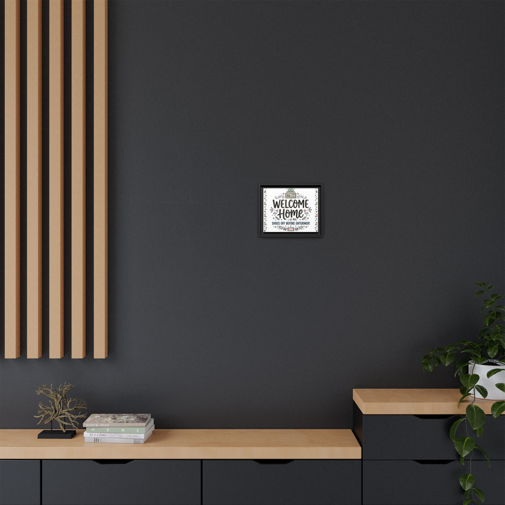Wall-mounted framed matte canvas showing “Welcome Home” and shoes-off message; black frame.