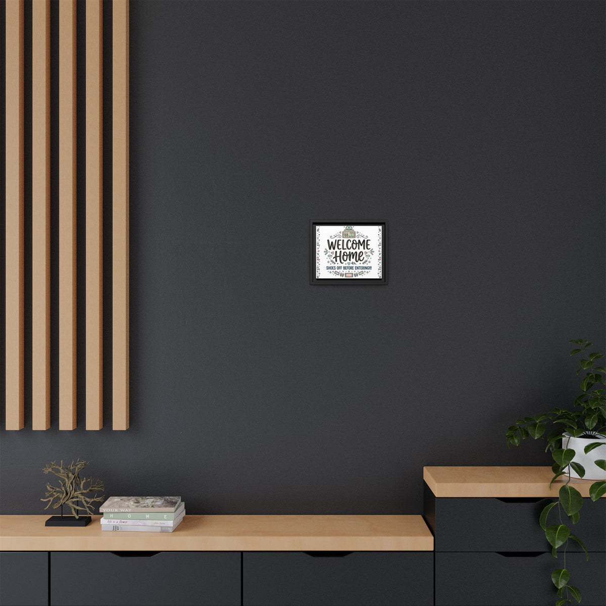 Wall-mounted framed matte canvas showing “Welcome Home” and shoes-off message; black frame.