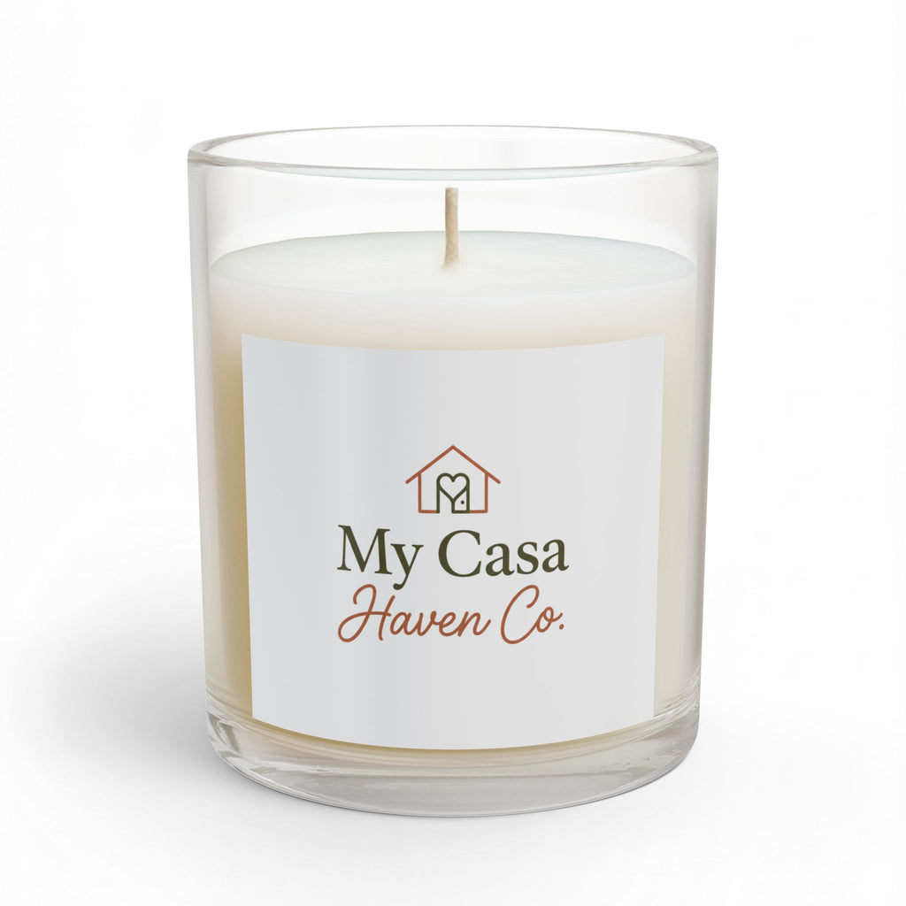 Glass candle in clear jar with white wax and lit wick, printed front label