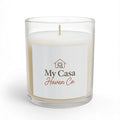 Glass candle in clear jar with white wax and lit wick, printed front label