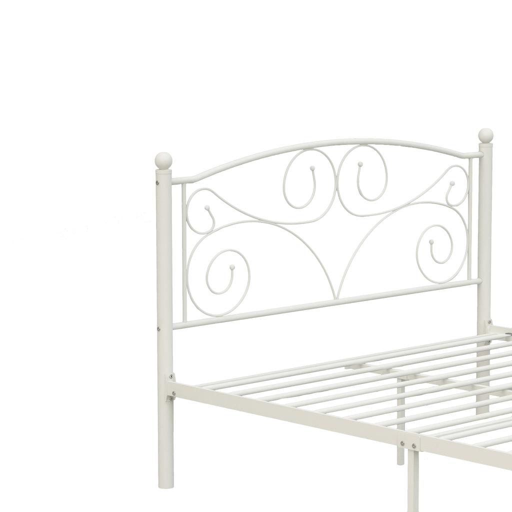 White metal bed frame close-up of scroll headboard and wire slatted lower rail