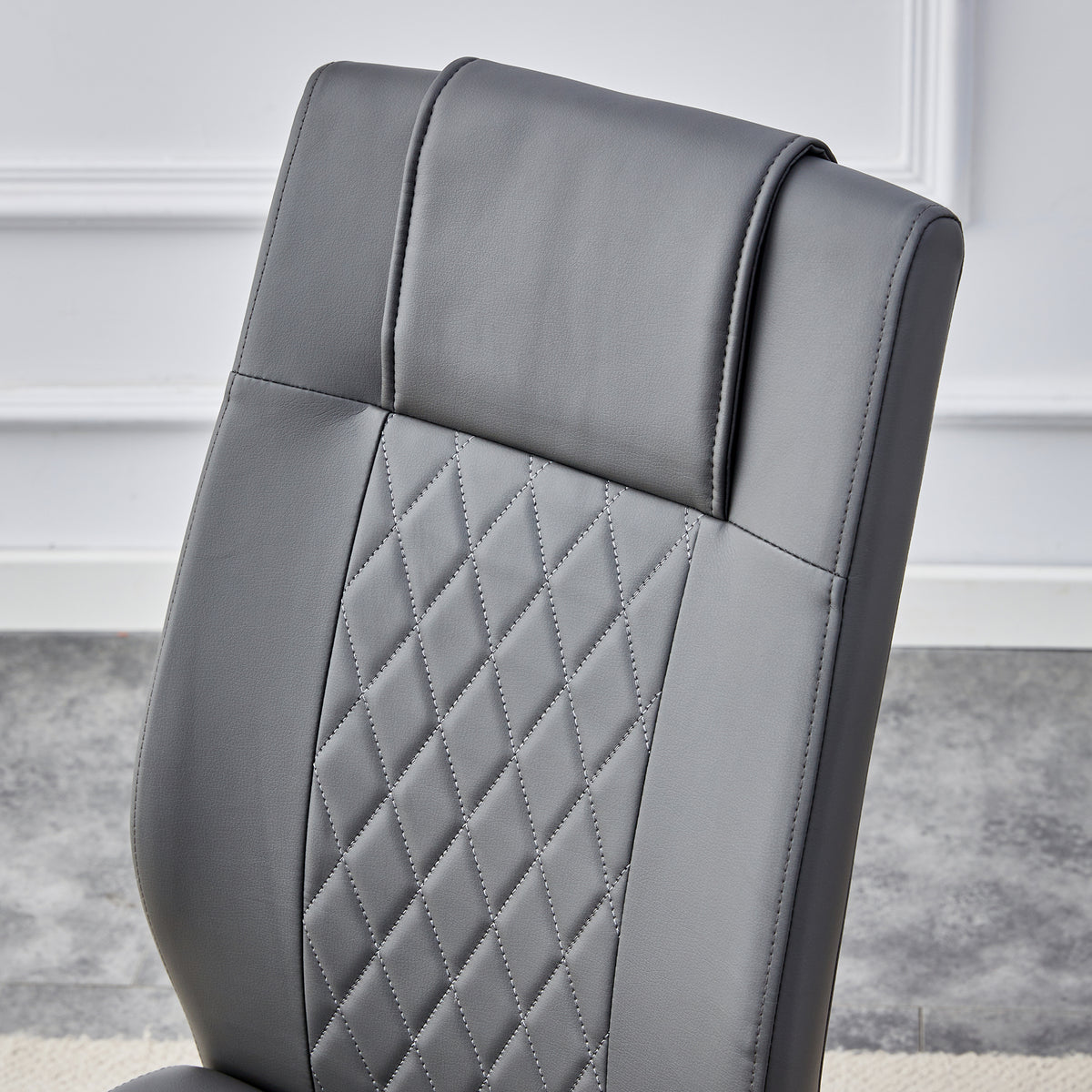 Gray faux leather chair back with quilted diamond pattern and cushioned headrest