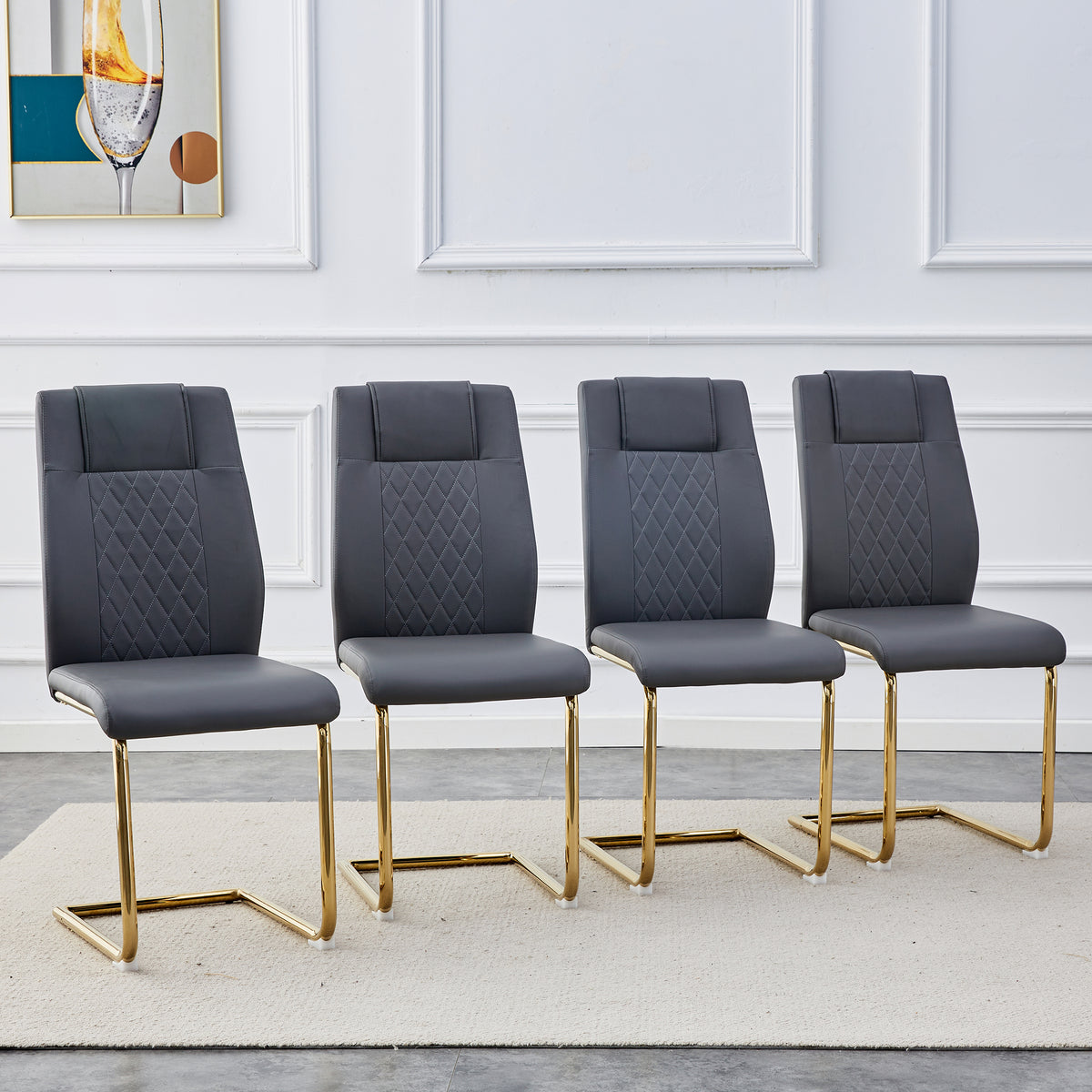 Four gray faux leather dining chairs with quilted backs and cushioned seats, gold metal legs.