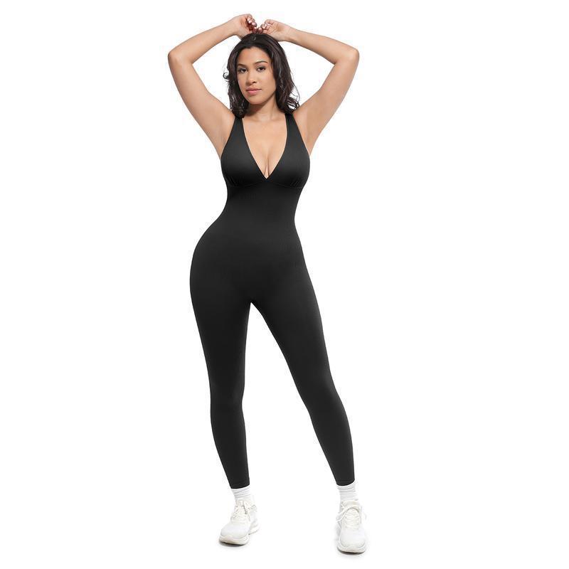 Black women's sleeveless V-neck jumpsuit with long fitted legs, hands behind head pose