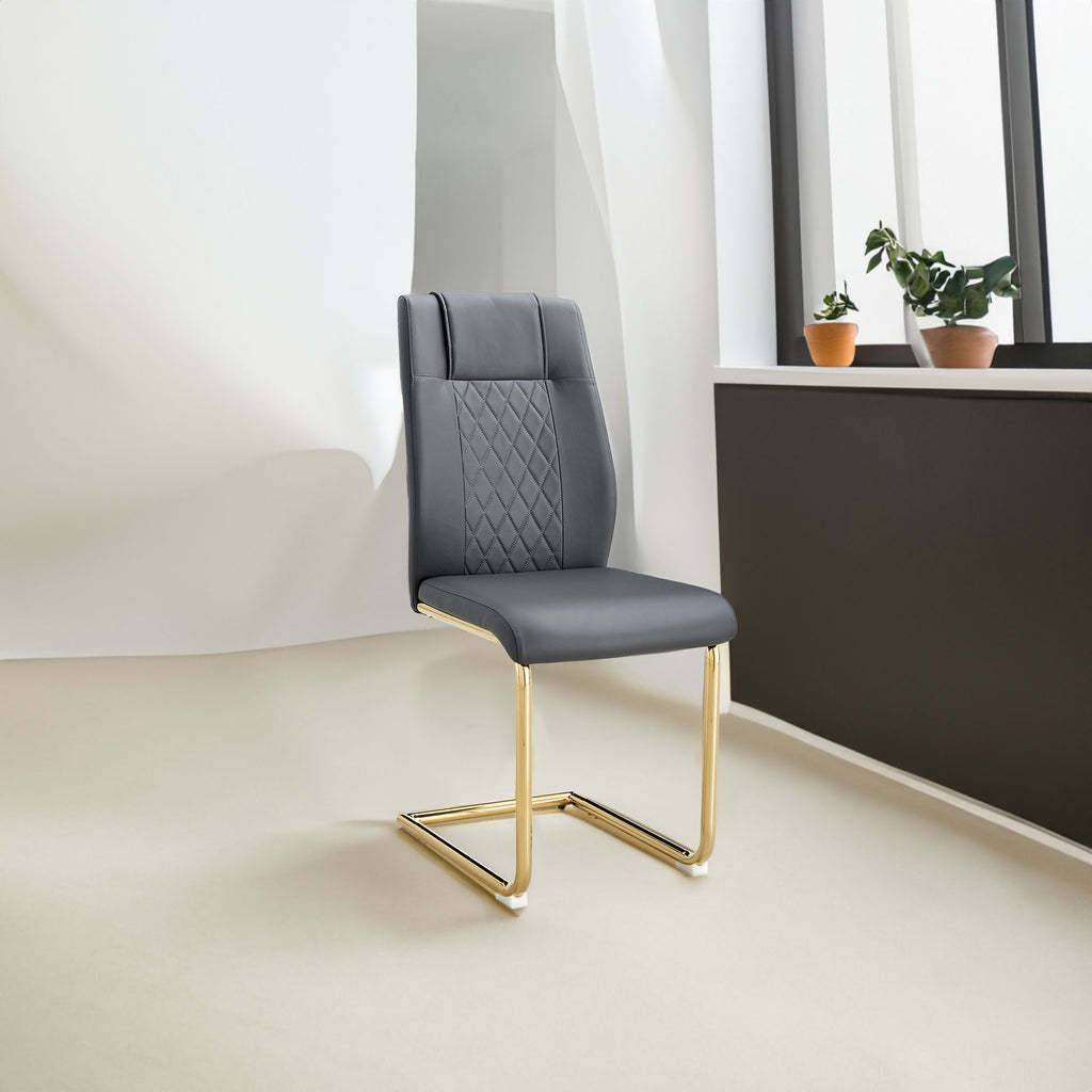 Gray faux leather dining chair with diamond-stitch back and gold metal sled legs