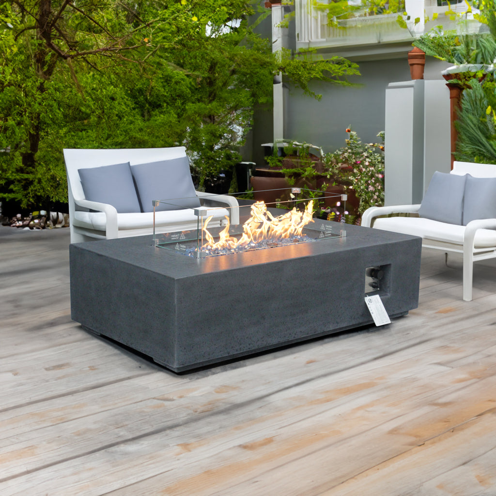 Dark gray rectangular outdoor propane fire pit table with glass wind guard and flames