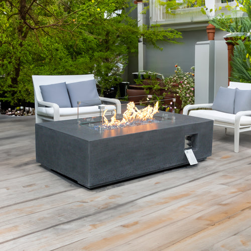 Dark gray rectangular outdoor propane fire pit table with glass wind guard and flames