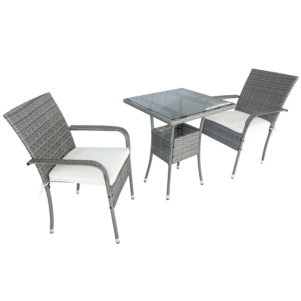 Grey wicker armchairs with white cushions and square glass table in a patio set layout
