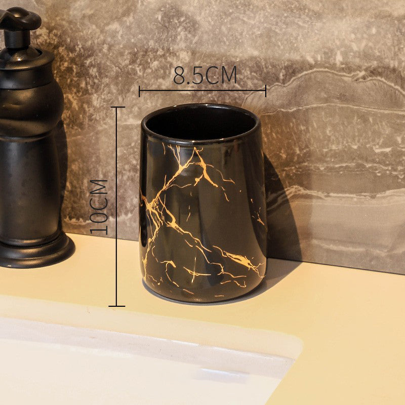 Black ceramic tumbler with golden marble veining, glossy finish, round rim
