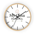 Round wooden wall clock with white dial and black hands, black hour marks.
