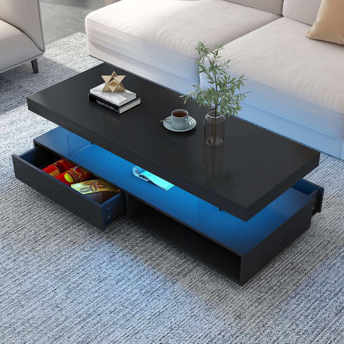 Black LED coffee table with blue-lit shelf and open drawers showing small items