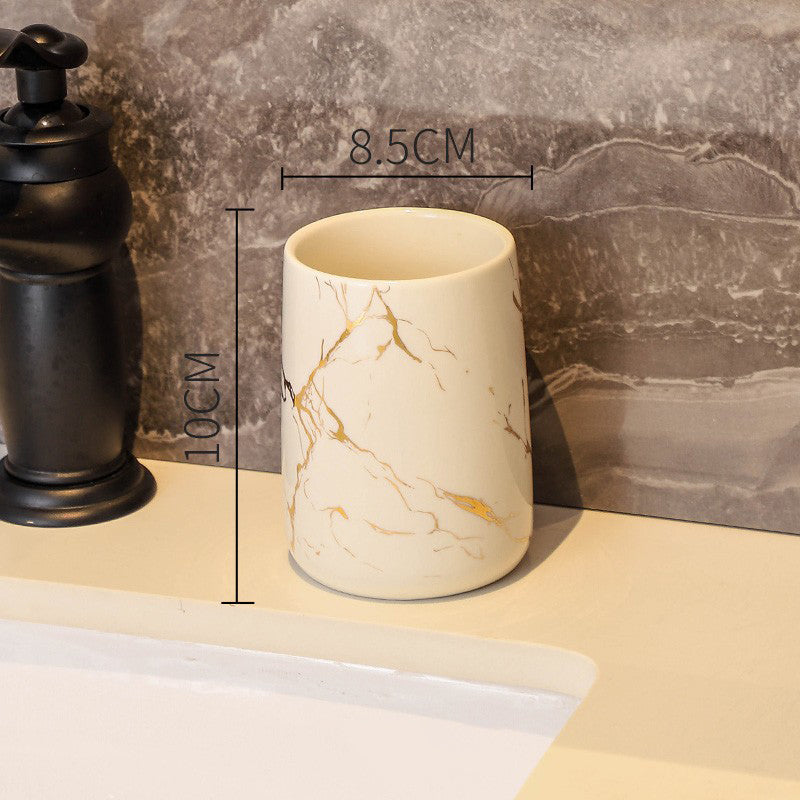 Cream ceramic tumbler with golden marble veining, glossy finish, round rim