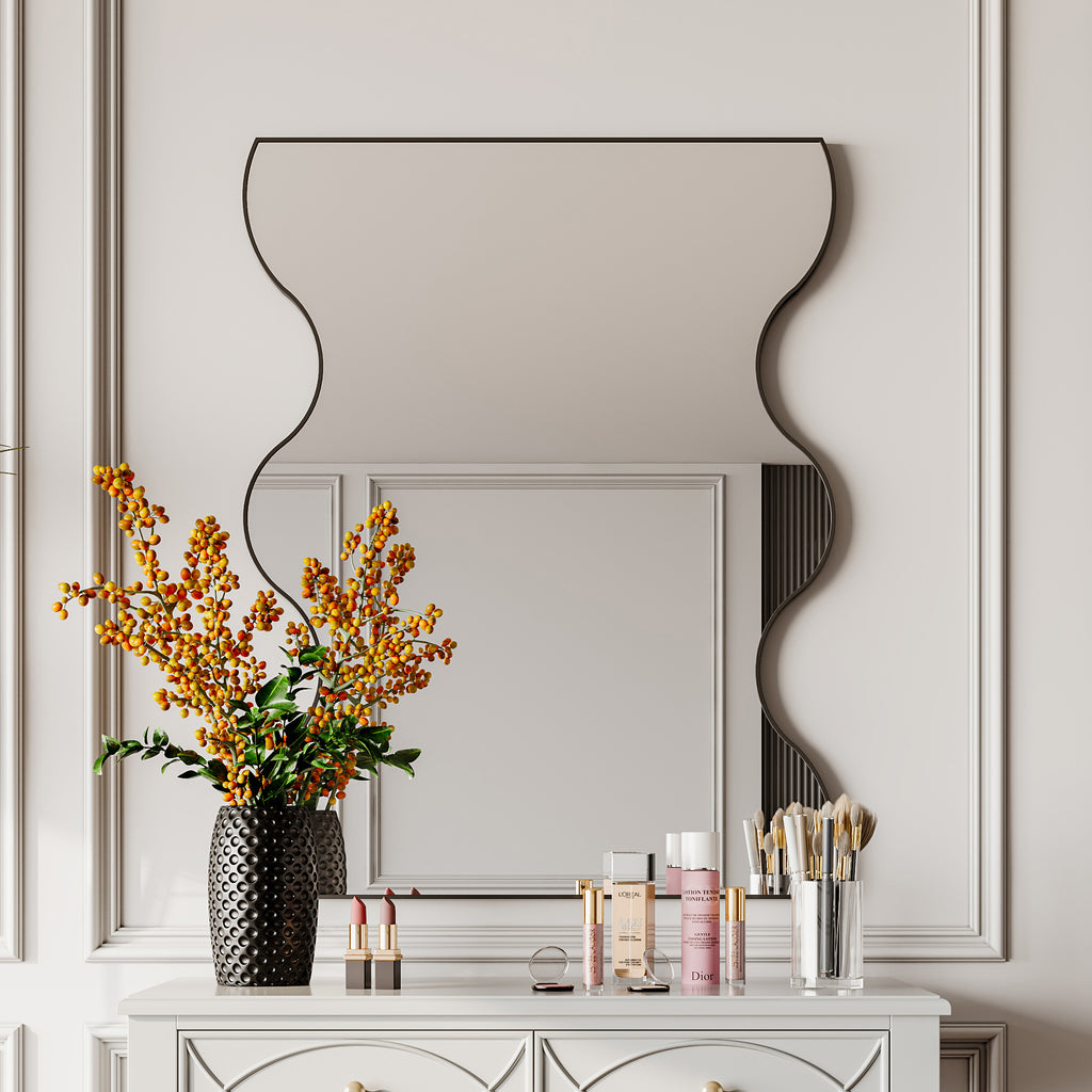 Wall mirror with wavy sides and black metal frame, shown mounted on wall