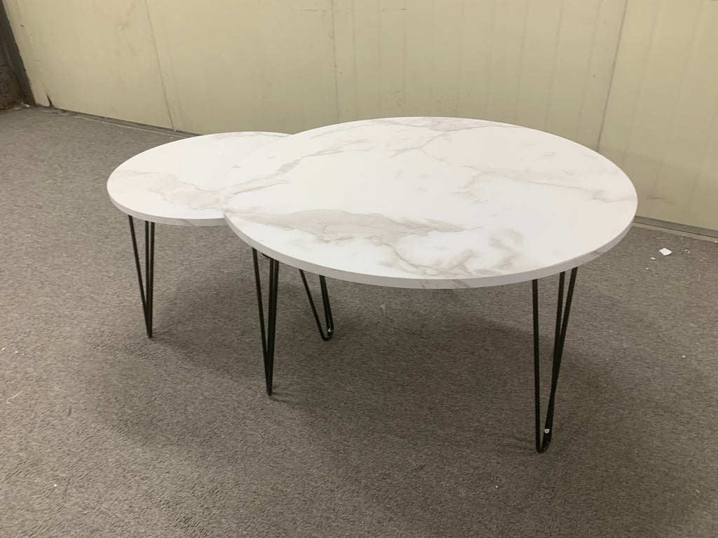 Two round nesting coffee tables with white marble-look tops and black metal legs