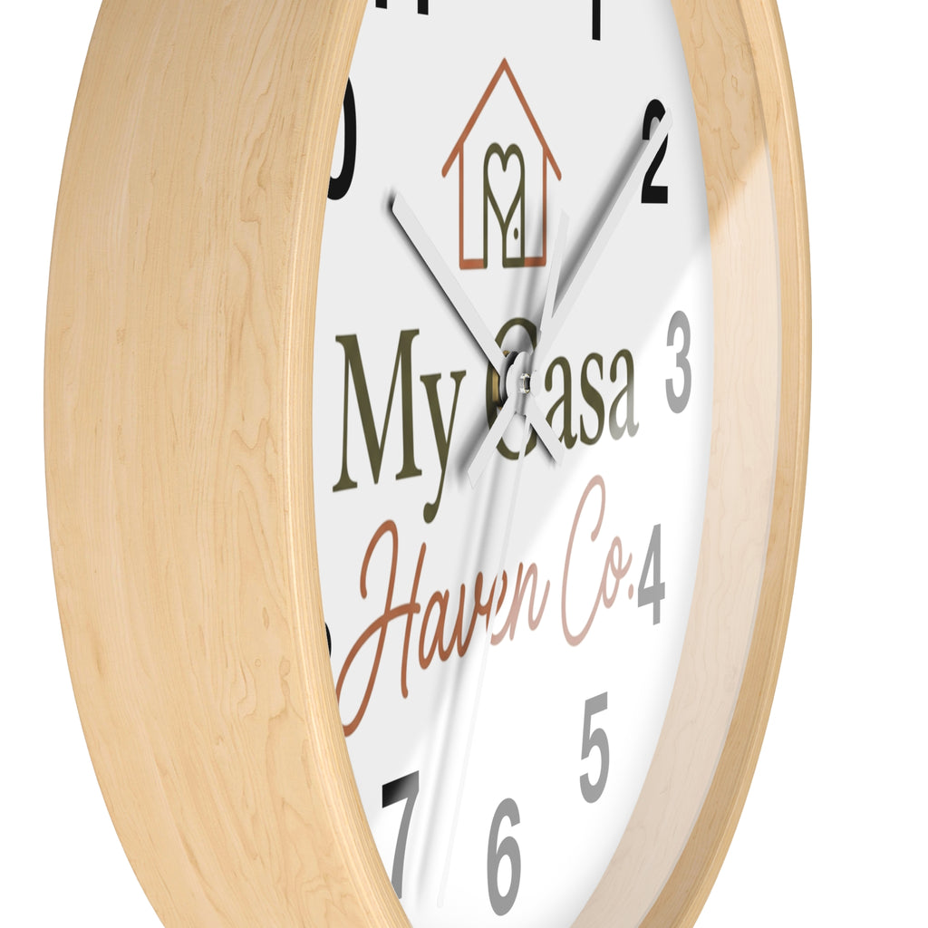Wood wall clock with light wood frame, close angled view of numbered white face and white hands
