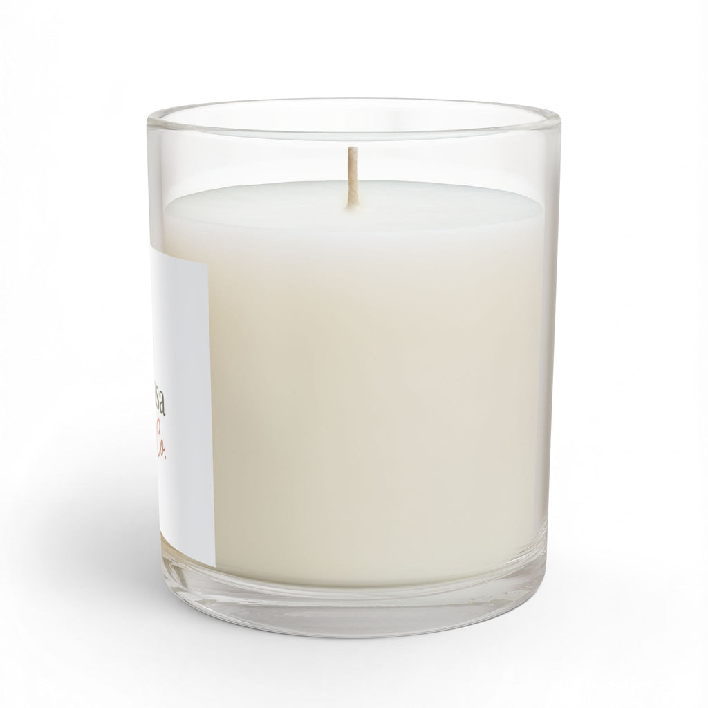 Glass candle in clear jar with creamy white wax and lit wick, side label