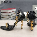 Black glossy high-heel chain sandals with ankle strap and gold-tone hanging chains