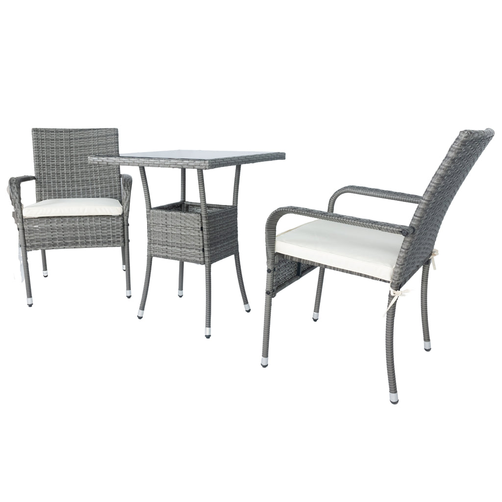Grey wicker patio set with two armchairs, white cushions, and glass-top table from side angle