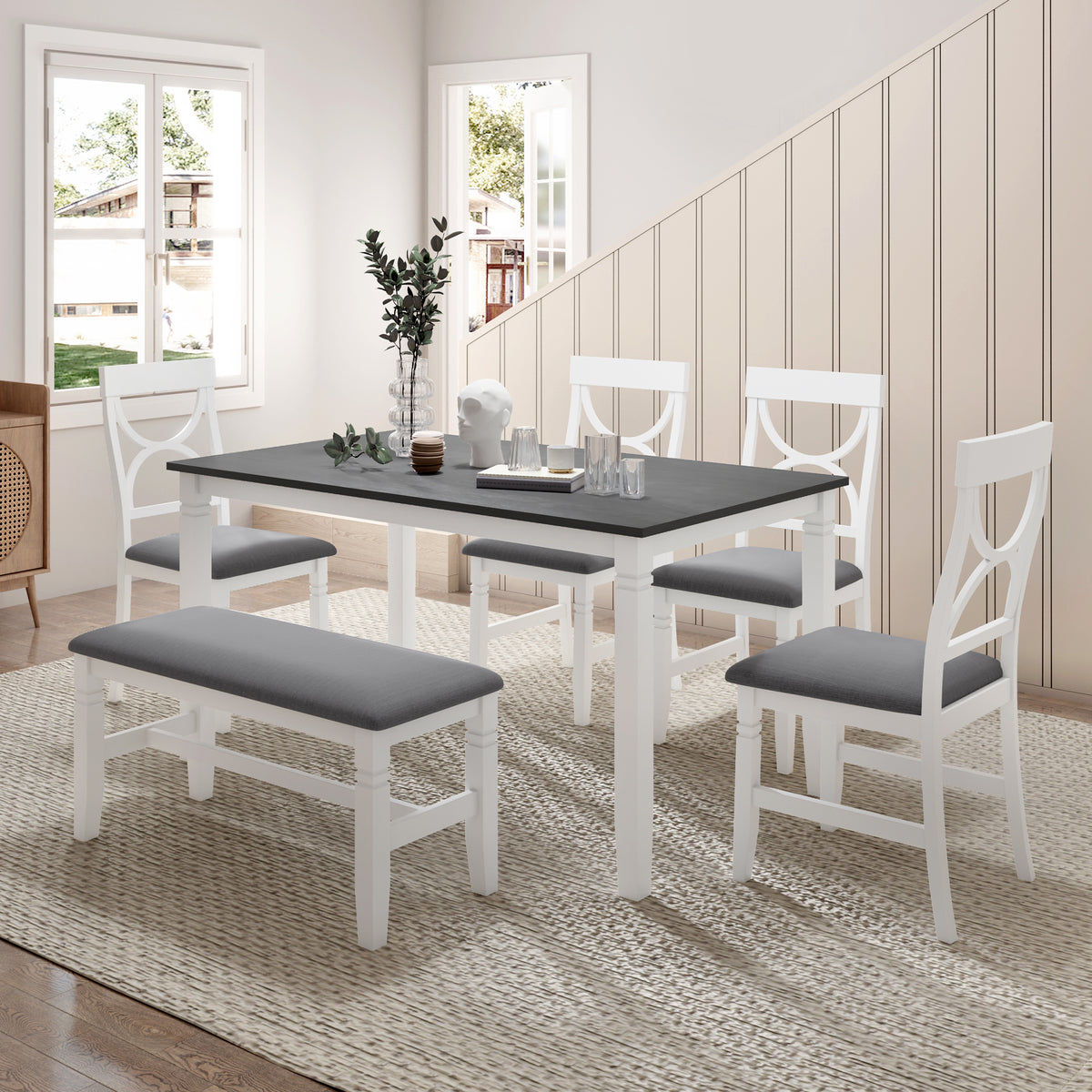 Gray dining table with white chairs and upholstered bench, all with gray seat cushions