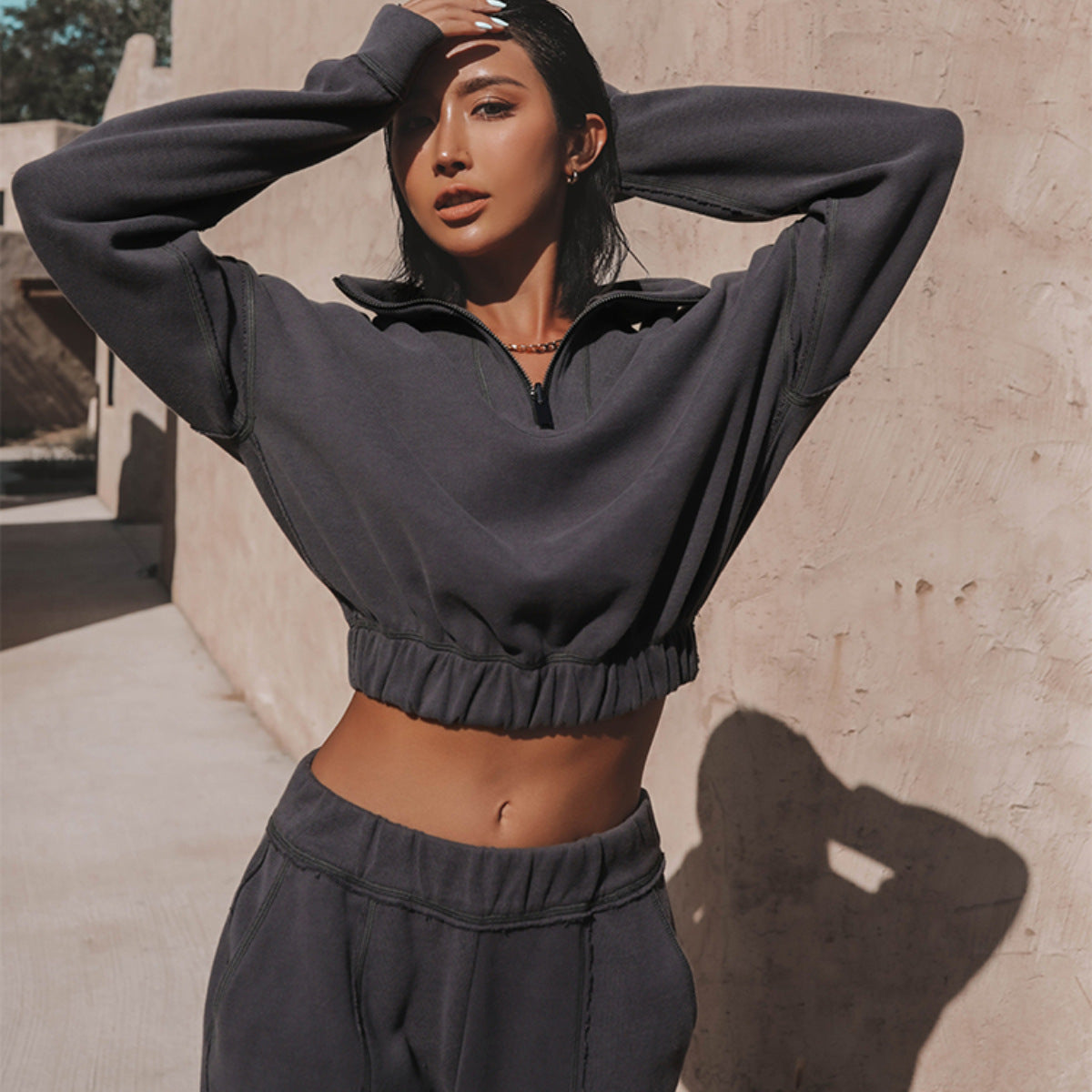 Dark charcoal cropped quarter-zip hoodie with elastic waist and matching pants set