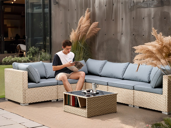 Outdoor sectional sofa with blue-gray cushions and beige woven rattan base, with armrests