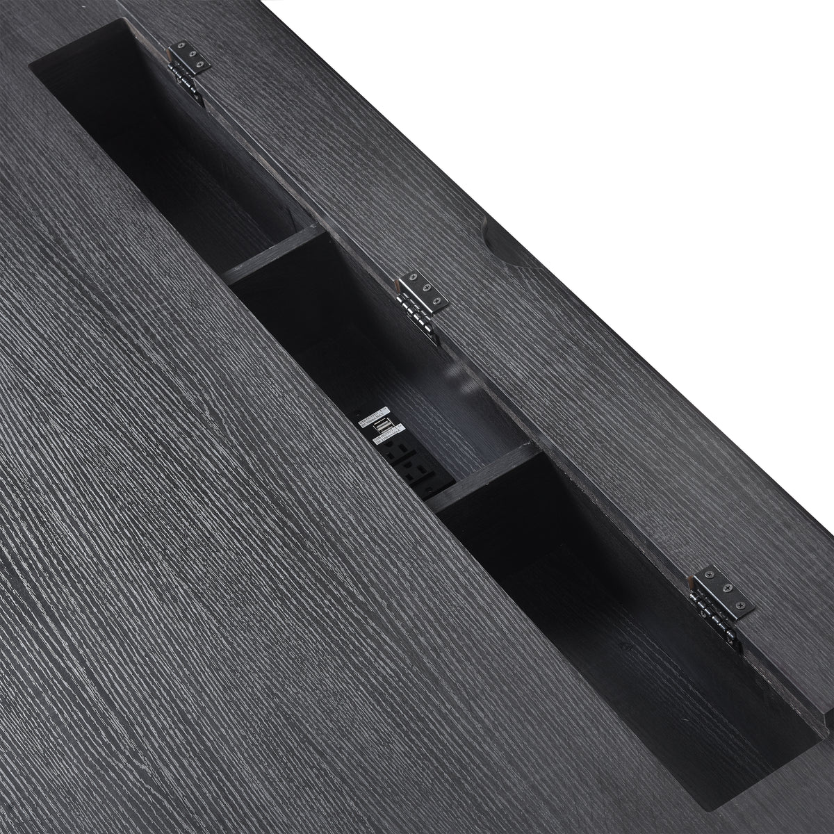 Black desk with open tabletop cable channel and built-in outlet switches inside.