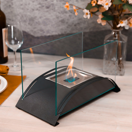 Black tabletop alcohol fireplace with clear glass panels and central flame