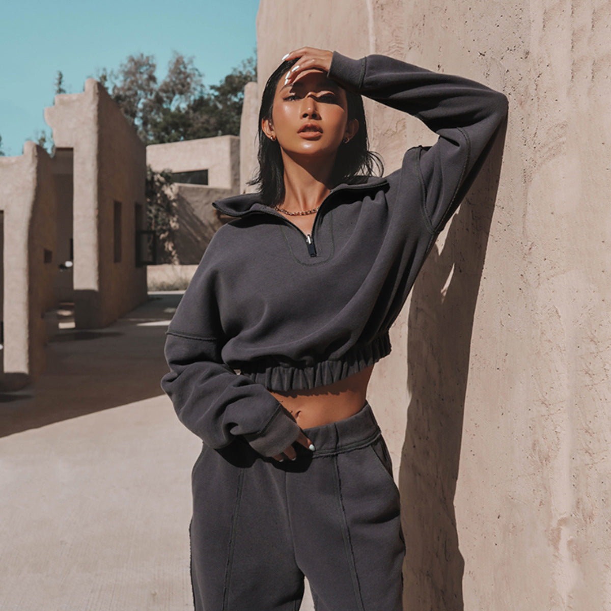 Dark charcoal quarter-zip hoodie with cropped hem and matching jogger pants set