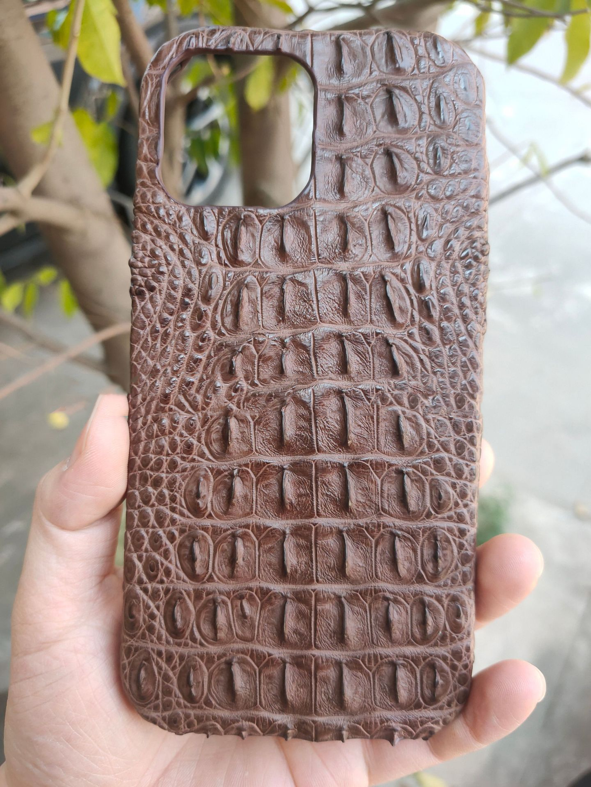 Brown crocodile leather phone case with embossed pattern and camera cutout