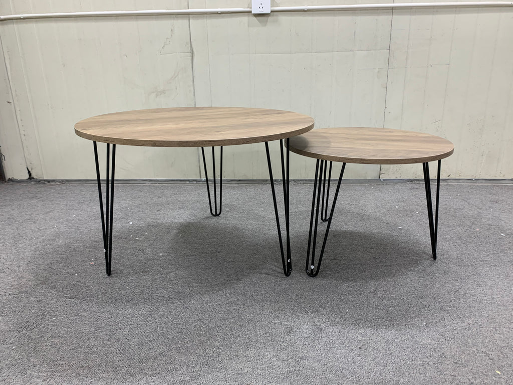 Two round nesting coffee tables with light brown wood surfaces and black metal frames