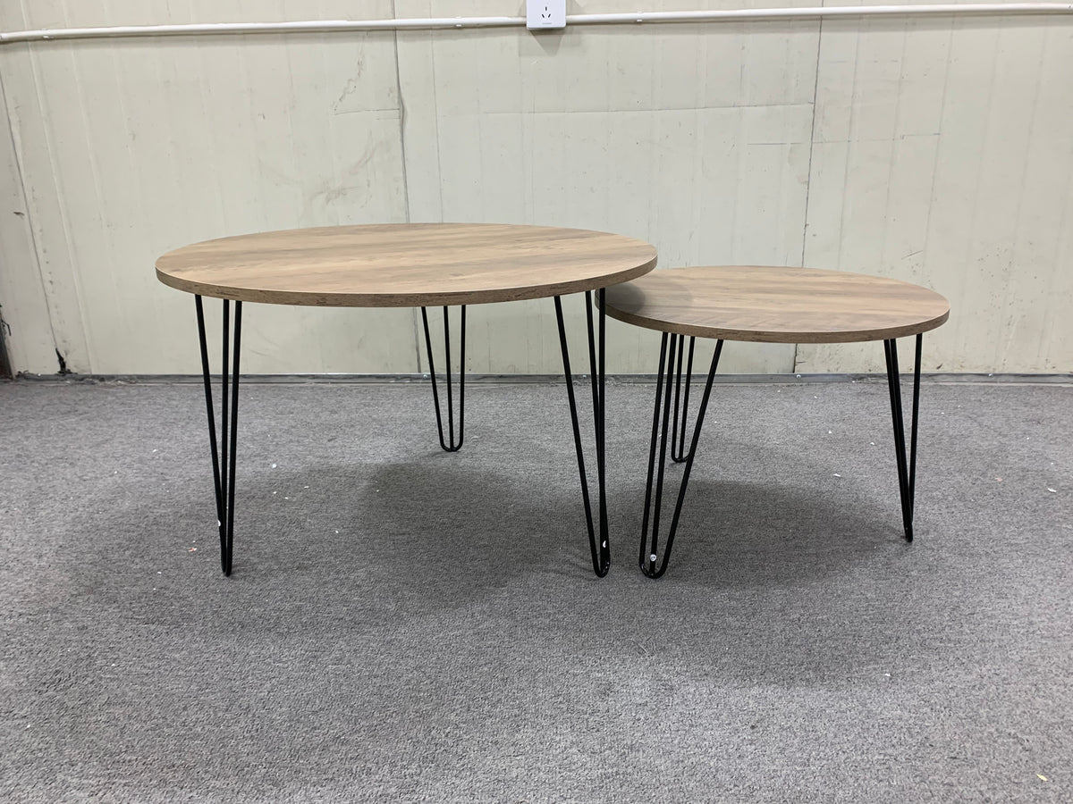Two round nesting coffee tables with light brown wood surfaces and black metal frames