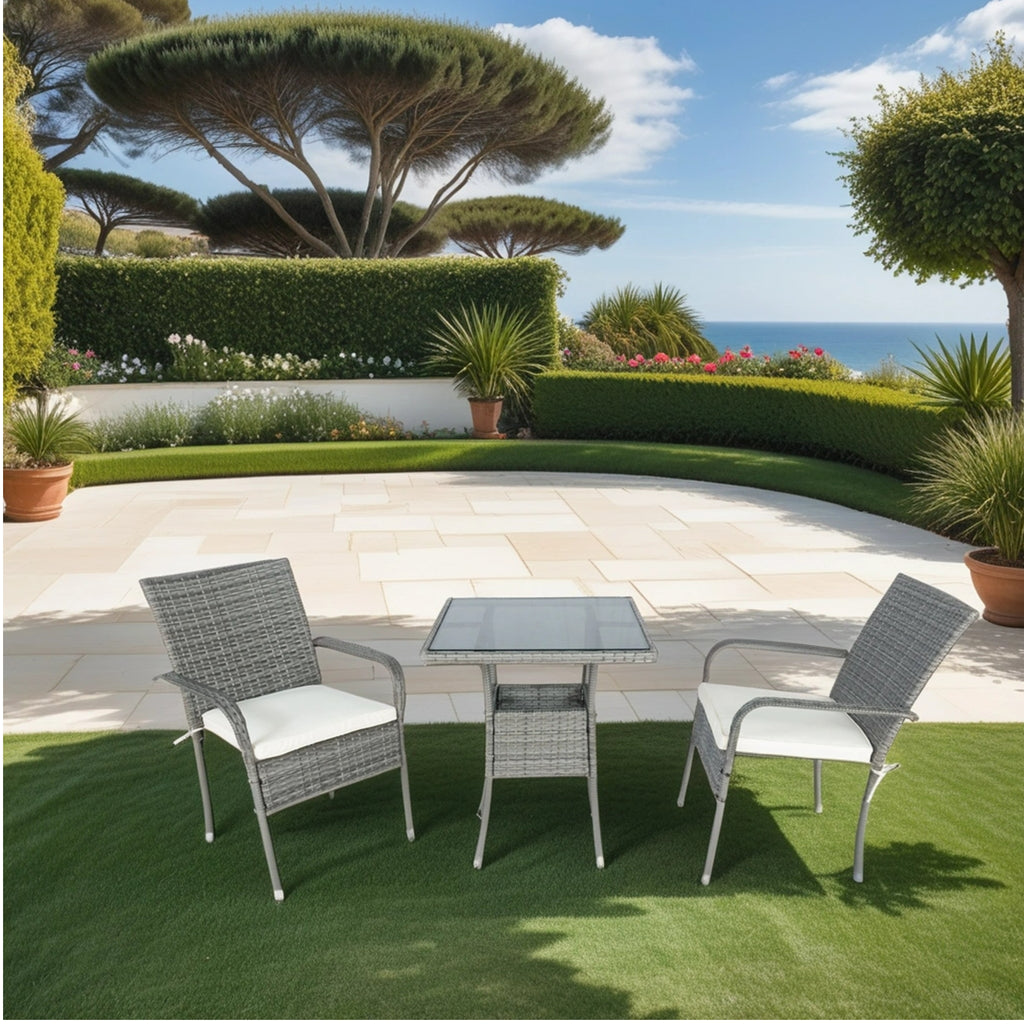 Grey wicker patio conversation set with white cushions and glass-top table, two chairs visible.