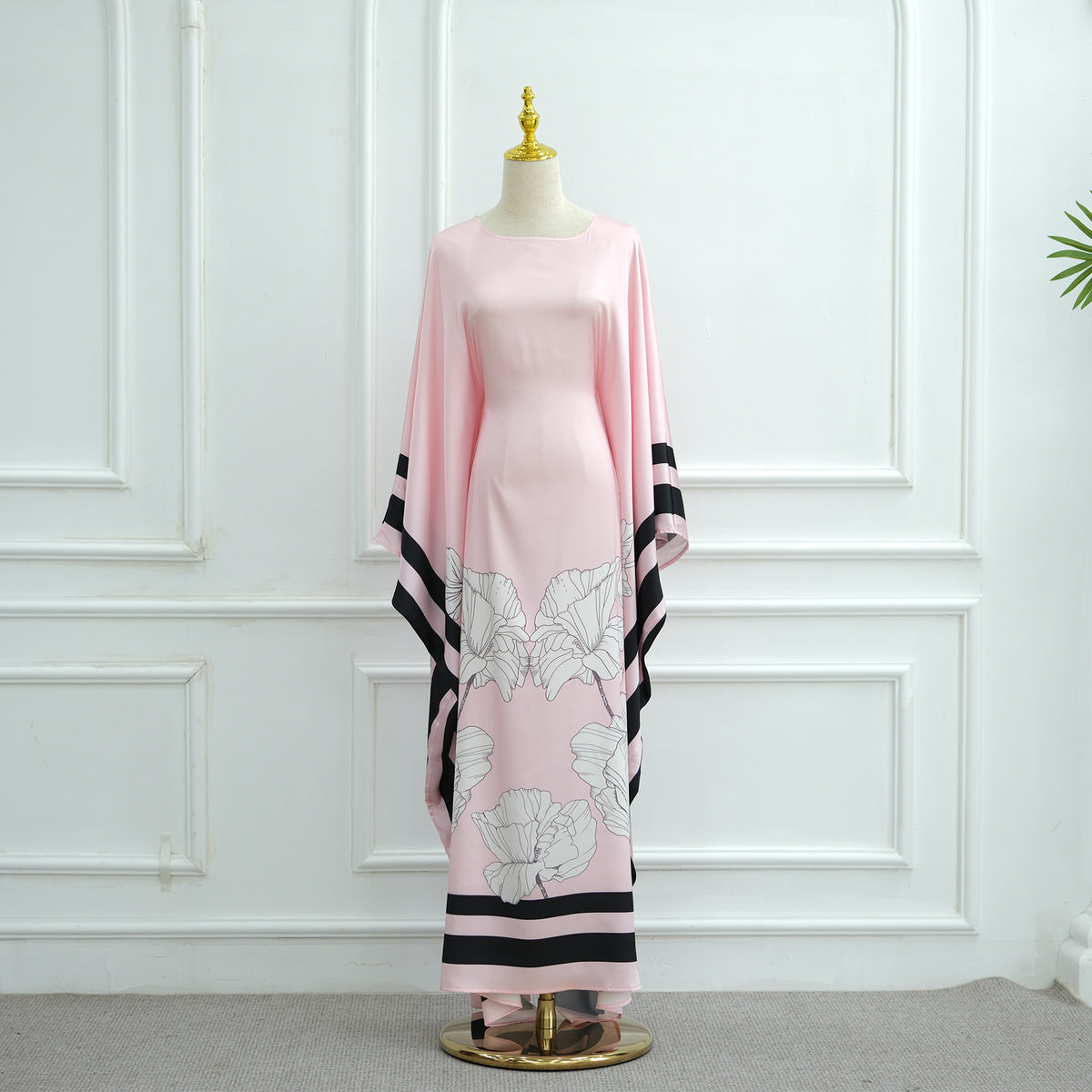 Pink printed dress with white floral motif and dark striped trim at sleeves and hem